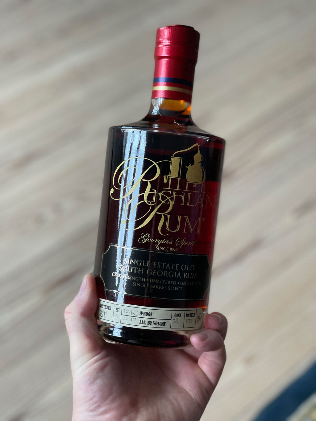 Flaske af Richland Rum 2011 Romhatten Cask #2 holdt i hånden